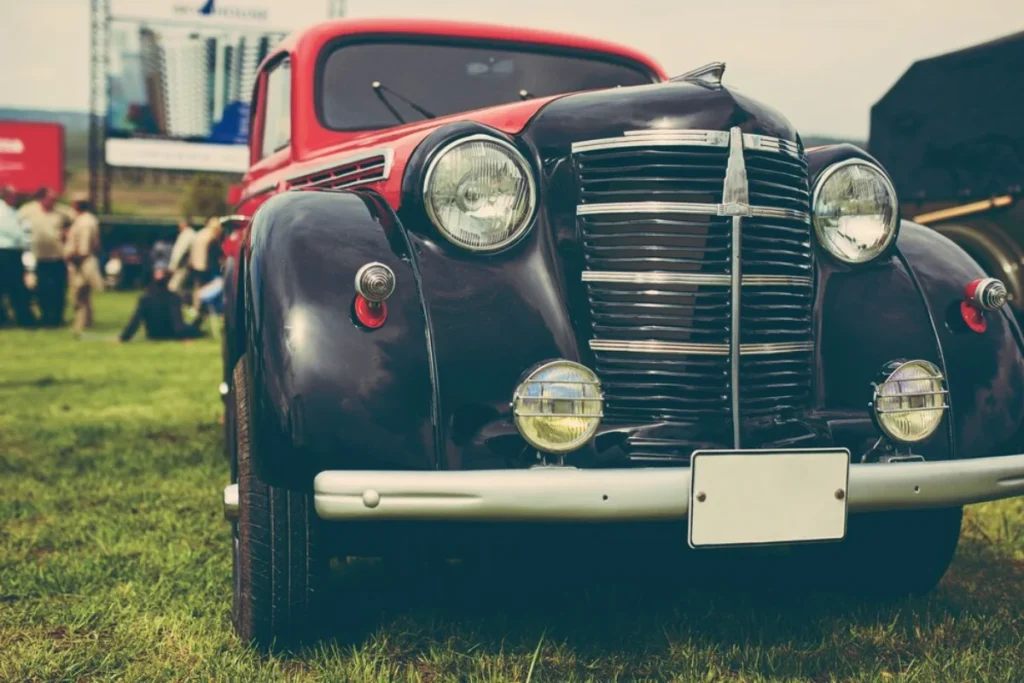 Close-up of a vintage black car with chrome accents at an outdoor car show