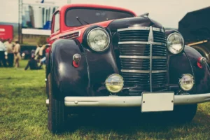 Close-up of a vintage black car with chrome accents at an outdoor car show