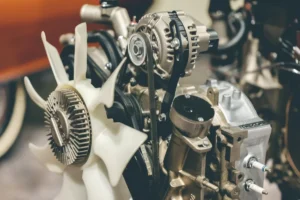 Close-up of a complex car engine showing belts, gears, and cooling fan