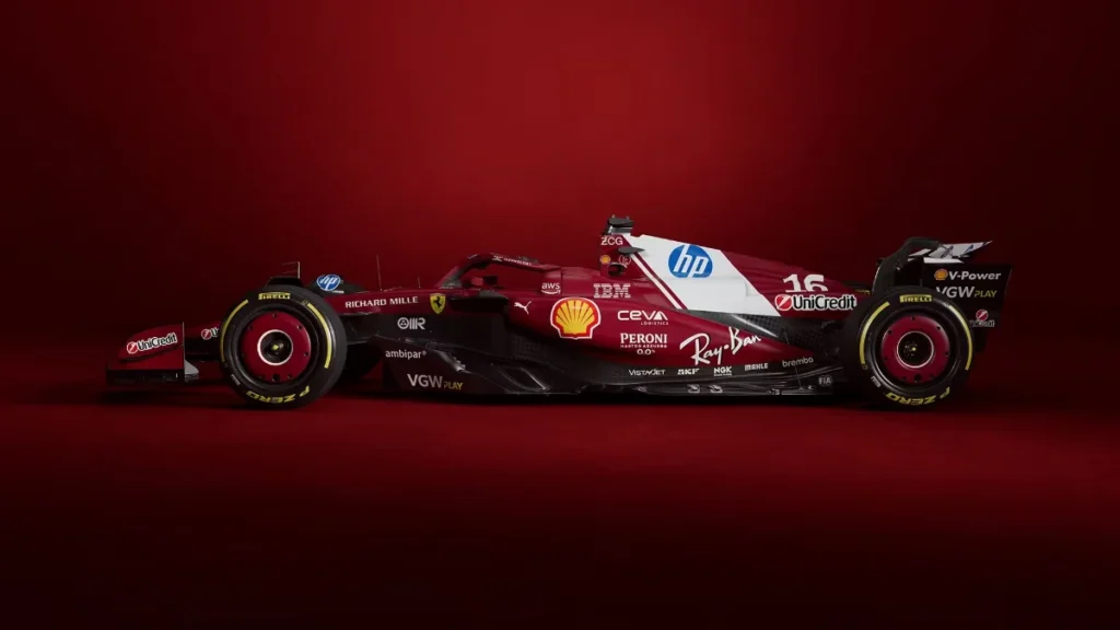A modern Formula 1 racing car, predominantly red, features sponsor logos including HP, Shell, and Ray-Ban